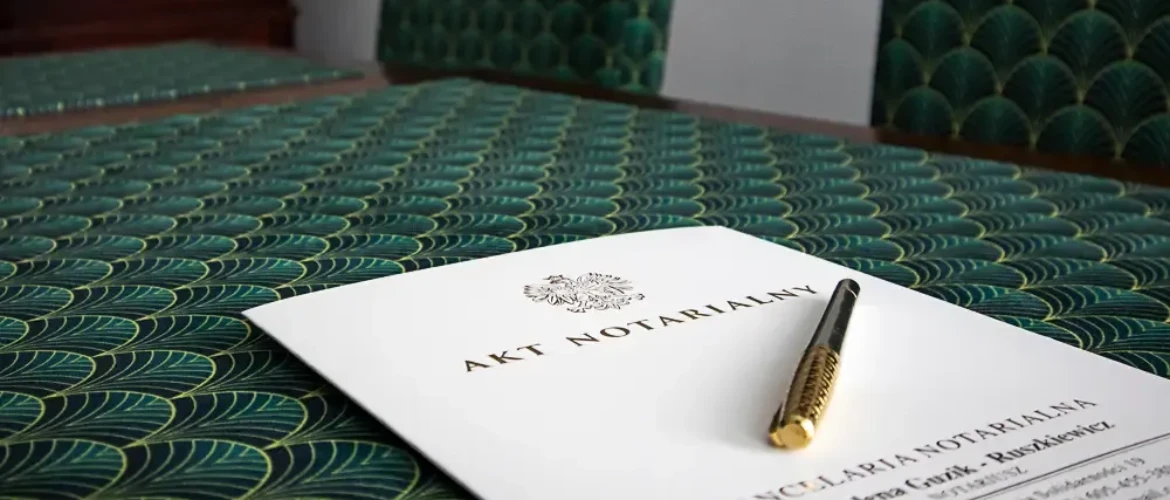 Stół z zieloną podkładką i leżącym aktem notarialnym